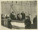 Black and white photograph of President Wilson and his wife stepping off of a ship after arriving in Paris, France.