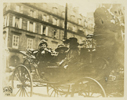 Black and white photograph of Edith Wilson and Mrs. Poincare riding through the streets in a carriage together.