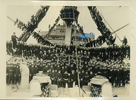 Black and white photograph of President Wilson, seated front and center, on a ship surrounded by Navy men at this base in France.