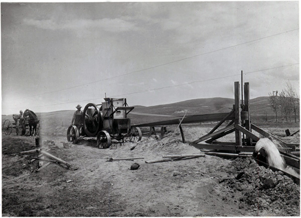 A photograph of an antique irrigation pump powered by an early internal combustion engine.