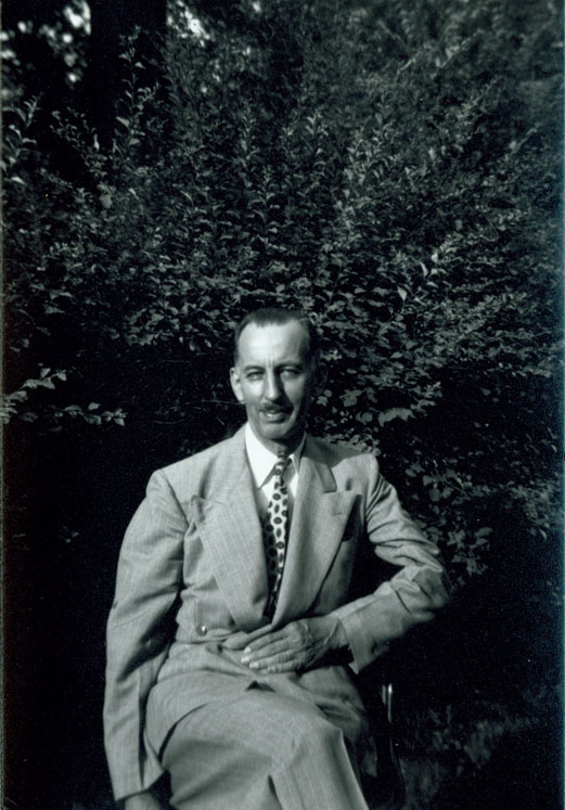 A photograph of Lowry Charles Wimberly seated in front of some greenery, 1940.